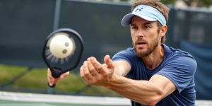 Pickleball player serving with spin in a dynamic action.